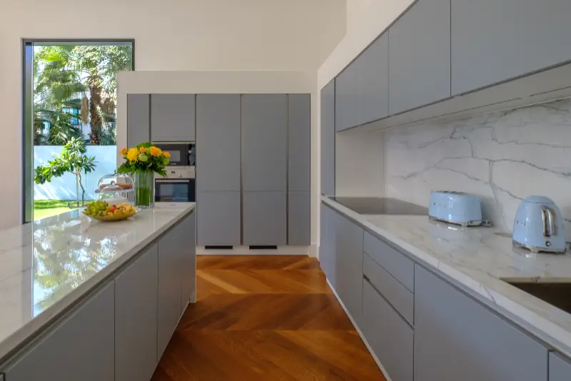 HAMALA, BAHRAIN - MARCH 02, 2019: Elegant modernist kitchen with a wooden floor in a luxury villa.